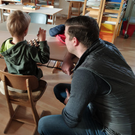 Ein Kind und ein Vater arbeiten mit Montessori Material